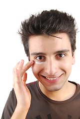 Image showing Smiling man applying eye cream