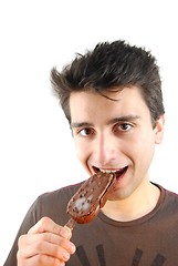 Image showing Portrait of a cute young man eating an ice-cream