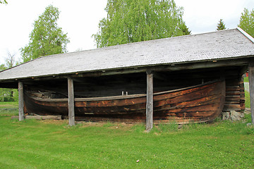 Image showing Old boat house and a boat