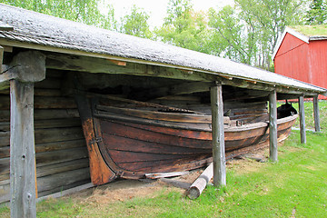 Image showing Old boat house and a boat