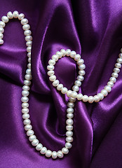 Image showing White pearls on a lilac silk background 