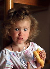 Image showing little girl eating croissant