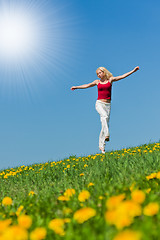 Image showing young woman in red outfit having fun on meadow