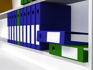 Image showing Green and blue folders laying on shelf