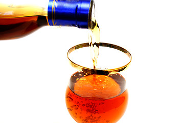 Image showing Bottleneck filling a glass with brown liquid