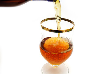 Image showing Bottle filling a glass with brown liquid