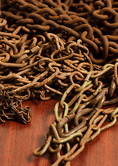 Image showing Rusty chain on wooden board