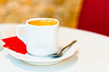 Image showing white cup of cappuccino coffee on light background with spoon