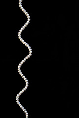 Image showing White pearls on the black silk 