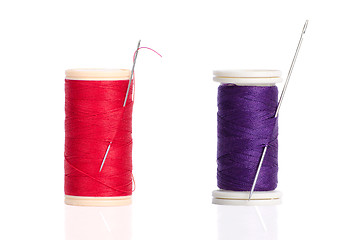 Image showing Two red and purple thread bobbin and needle 