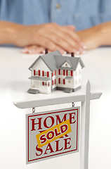 Image showing Womans Hands Behind House and Sold Real Estate Sign