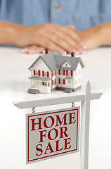 Image showing Womans Hands Behind House and Real Estate Sign in Front