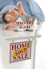 Image showing Sold Real Estate Sign in Front, Woman Reaching for House