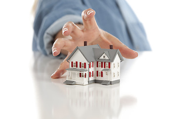 Image showing Womans Hand Reaching for Model House on White