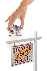 Image showing Womans Hand Choosing Home with Sold Real Estate Sign