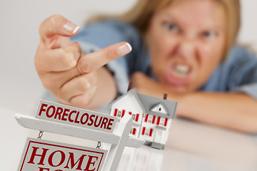 Image showing Woman Flipping The Bird Behind Model Home and Foreclosure Sign