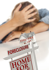 Image showing Woman, Head in Hand Behind Model Home and Foreclosure Sign