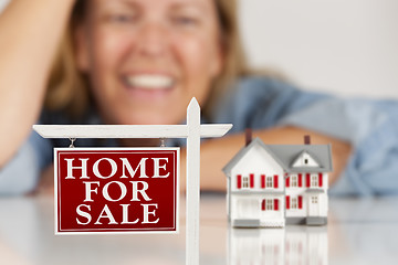 Image showing Smiling Woman Behind Real Estate Sign House on a White Surface