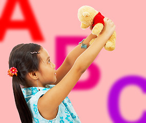 Image showing Girl Holding Her Teddy Bear Up In The Air