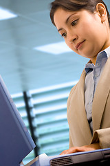 Image showing A Businesswoman At Her Desk Using A Notebook Computer