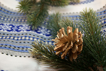 Image showing Green spruce boughs and a gilden cone in a traditional embroider