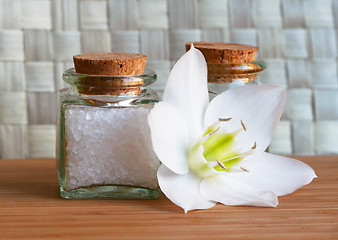 Image showing Bottles of sea salt and oil with white flower