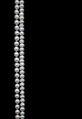 Image showing White pearls on the black silk