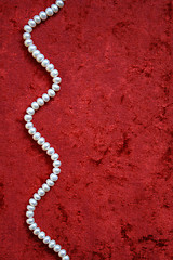 Image showing Necklace of white pearls on a terracotta velvet background 