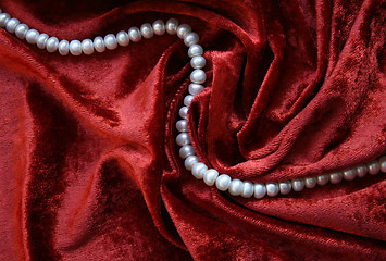 Image showing Necklace of white pearls on a terracotta velvet 