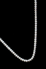 Image showing White pearls on the black silk 