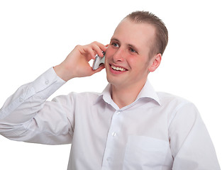 Image showing The young man says with a smile on your mobile phone