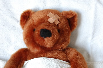 Image showing sick teddy with injury in bed