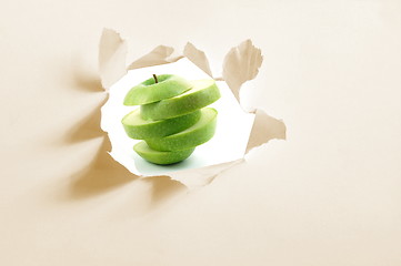 Image showing sliced apple and hole in paper