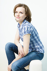 Image showing attractive young girl sitting on the couch home