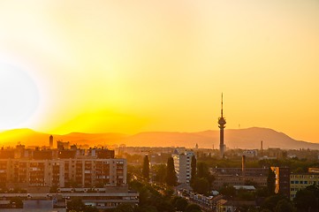 Image showing City at dawn with apartments and tower and mountains