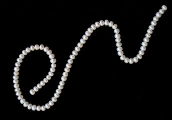 Image showing White pearls on the black silk