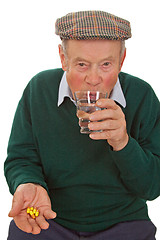 Image showing Male senior taking medicine