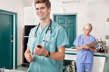 Image showing Doctor with syringe while nurse taking down report