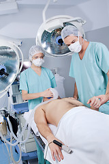 Image showing Doctor and nurse preparing the patient for operation