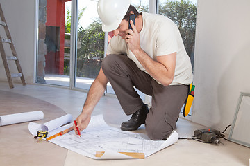 Image showing Construction worker working on blueprint