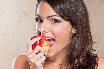 Image showing Pretty young woman eating an apple