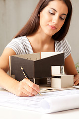 Image showing Young Female Architect with Model house