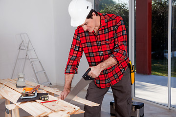 Image showing Construction Worker Using Hand Saw