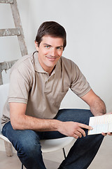 Image showing Mature man holding color swatch in his hand