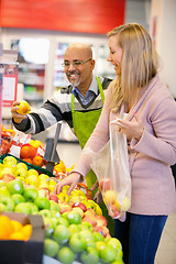 Image showing Happy young woman buying fruits