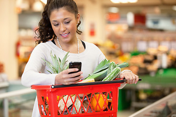 Image showing Smiling woman using mobile phone in shopping store