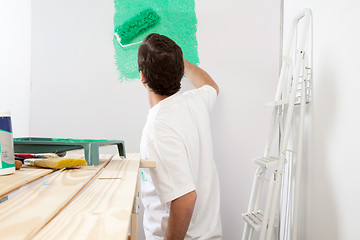 Image showing Man painting the wall with roller