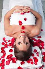 Image showing Smiling beautiful woman lying on a massage table