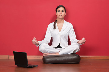 Image showing Businesswoman sitting in yoga lotus position