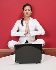 Image showing Businesswoman meditating in yoga lotus position